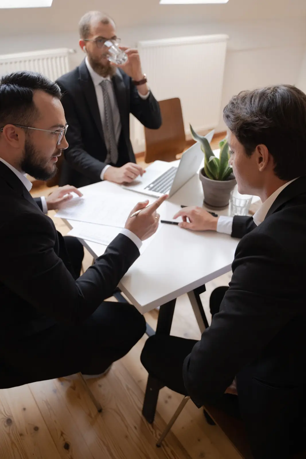 Business owners in suits in a serious meeting around an office table